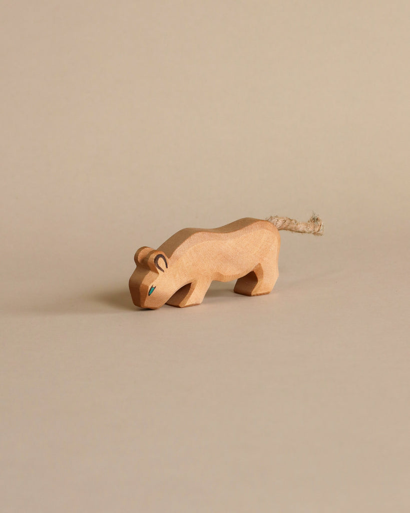 The Ostheimer Handmade Wooden Safari Animals Set features a handcrafted wooden big cat figurine with simple carved details and a rope tail, perfect for imaginative play, set against a plain beige background.