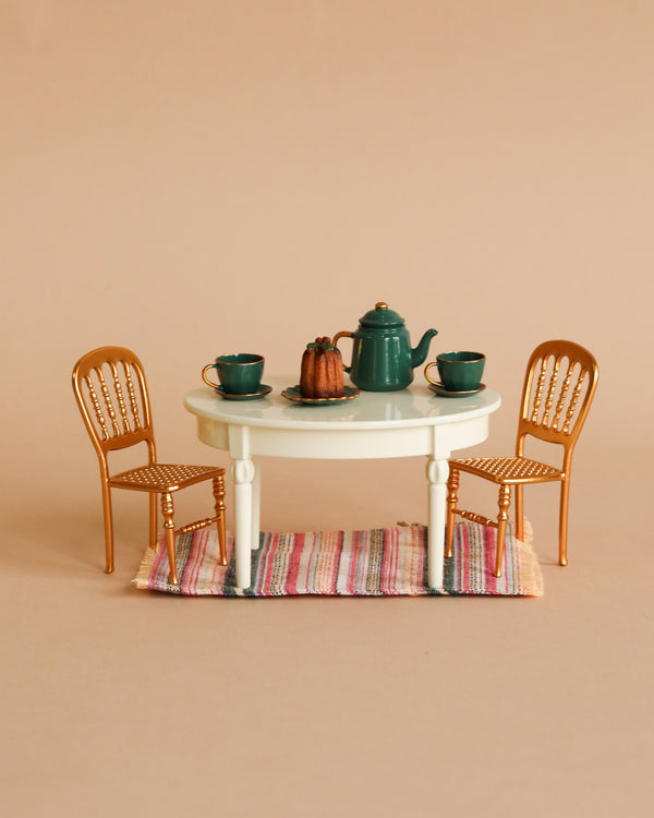 Miniature table with tea set and two gold chairs