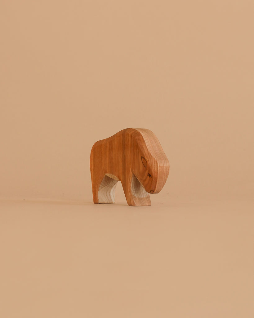 The Ostheimer Bison, Small is a handcrafted, minimalist wooden animal figure in light brown, inspired by traditional German Ostheimer toys. It stands on a plain beige background and features simple artisanal details.