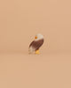 The Ostheimer Bird - Bald Eagle, Standing is a small, handcrafted wooden figurine with brown wings, a white head, and a yellow beak—showcasing the quality of toys Germany is renowned for.