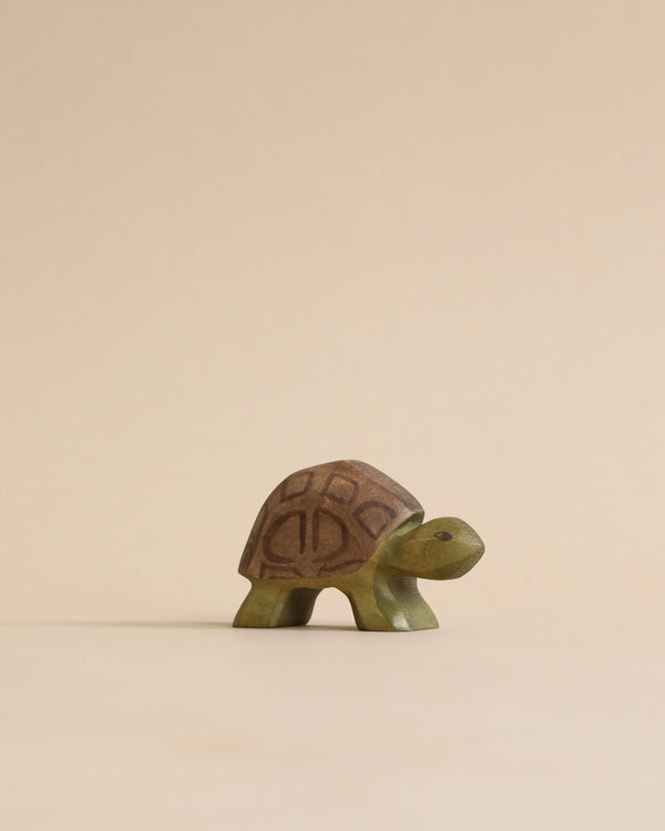 A Handmade Holzwald Turtle figurine with a detailed, patterned shell designed for imaginative play, standing against a soft beige background.