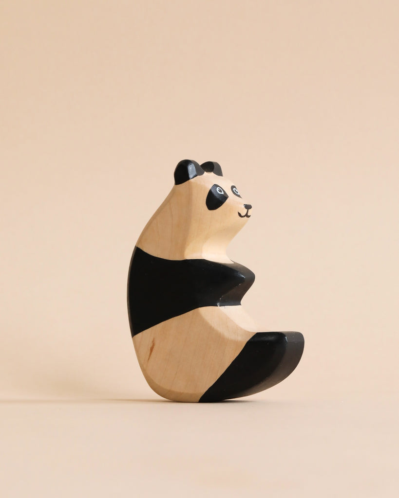 A high-quality Handmade Holzwald Panda figurine painted with black and white stripes, seated against a plain beige background.
