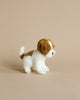 A small, lifelike Jack Russel Tea Cup Dog Stuffed Animal with a white and brown coat, standing against a plain, light beige background.