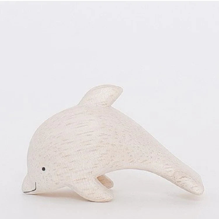 A Handmade Tiny Wooden Dolphin, hand-carved from eco-responsible forests, featuring a simple, smooth design with subtle wood grain texture, and a cheerful expression crafted with a small dot for an eye.