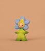 The Handmade Wooden Flower Child Forget-Me-Not, with a smiling face, yellow hair, blue flower head, and green leaf outfit, stands against a beige background—ideal for fostering emotional intelligence in Waldorf toy collections.