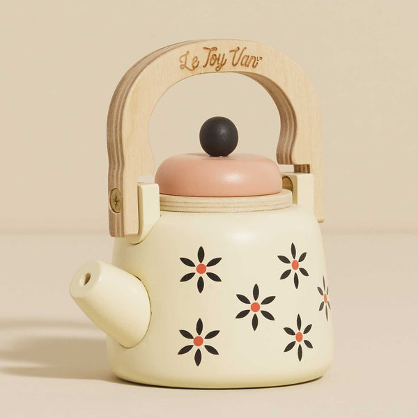 The Vintage Wooden Role Play Kettle is a delightful cream-colored toy teapot featuring a wooden handle made from FSC-certified wood. It boasts a design of stylized black flowers with red centers and has a light pink lid topped with a black knob. The "Le Toy Van" engraving adds to its eco-friendly charm.