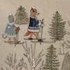 The Coral & Tusk Winter Fun Pillow features embroidered woodland animals—a cat and a fox—in winter outfits skiing through a snowy forest, with evergreen trees, a white rabbit, and festive details, perfect for holiday decor.