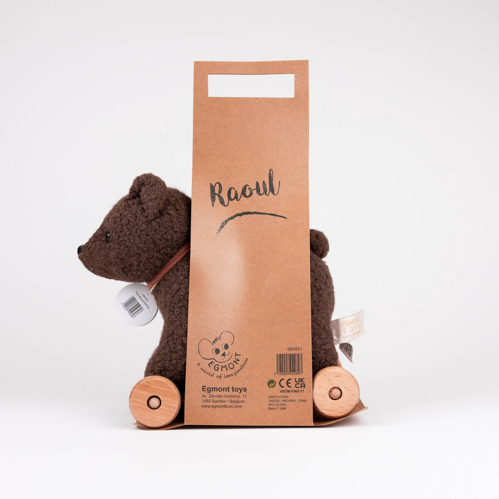 A charming plush brown bear named "Pull-Along Raoul," featuring wooden wheels and a paper handle labeled with its name, is photographed against a plain white background—thoughtfully crafted by Egmont Toys.
