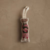 The Coral & Tusk Mouse with Wreath Ornament, wearing festive attire and featuring a loop for easy hanging, rests on a textured beige surface—an adorable addition to any holiday wreath.