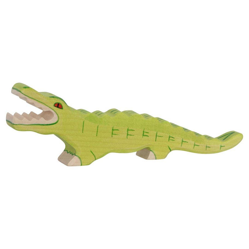 The Holztiger Crocodile is a handcrafted wooden toy, painted green with dark green details, open mouth, visible teeth, and red eyes on four short legs. Made in Europe, it's perfect for imaginative play.