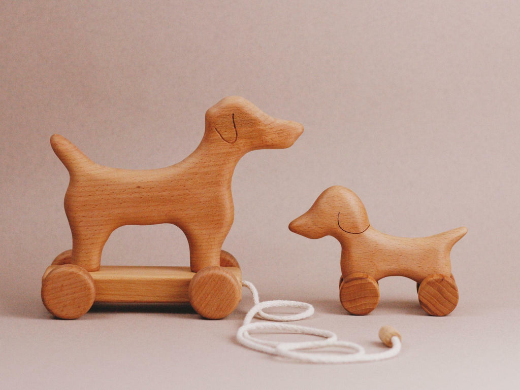 Introducing the Handmade Wooden Mini Dog Push Toy, a charming toy on wheels that is ideal for children to enjoy during playtime.