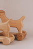 A Handmade Wooden Dog Pull Toy crafted from rich maple and beech wood, featuring wheels.