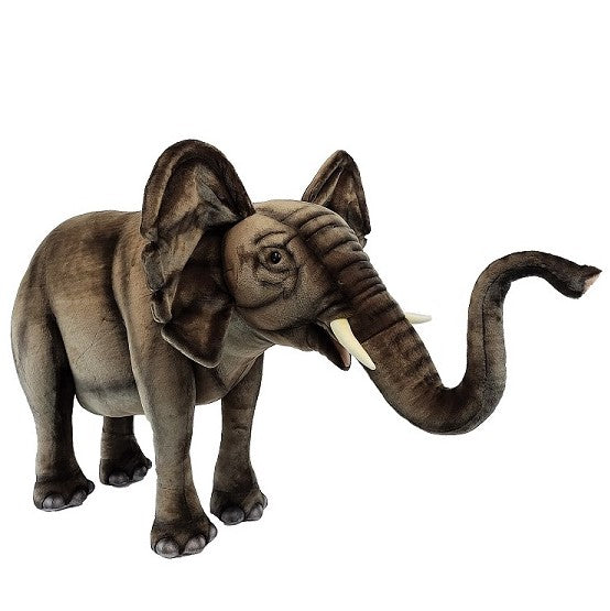 The Ride-On Elephant - Final Sale features brownish-grey fur, large ears, white tusks, and a raised trunk. Standing on four legs against a white background, it’s perfect for fans of realistic animal toys.
