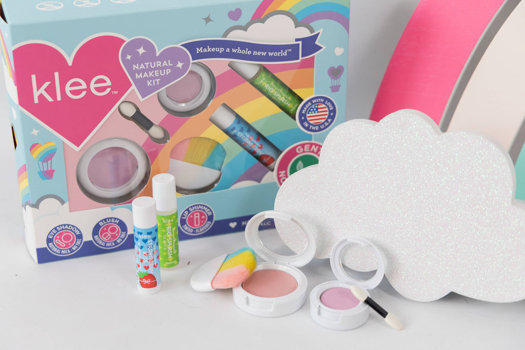 Klee Naturals Makeup Kit - After the Rain- Rainbow Dream displayed with two lip balms, a blush compact, a purple eyeshadow compact with an applicator, and a sparkly cloud-shaped cutout.