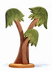 A minimalist wooden sculpture of a palm tree with two trunks and green, stylized fronds atop a round base. Handcrafted from the Ostheimer Palm Trees With Stand, the reddish-brown tree trunks and various shades of green fronds inspire imaginative play.