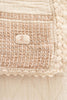 Close-up of the Organic Cotton Baby Blanket - Farm, featuring textured beige woven fabric, a crochet trim, and a centered label with "NEVER AGAIN" and a decorative logo above.