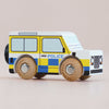 The No. 40 GT250 Bobby, made in England, is a wooden toy inspired by a classic British patrol vehicle. It features blue and yellow checkerboard patterns, black wheels, and the word “POLICE” on the side—perfect for imaginative play and striking against a plain light background.