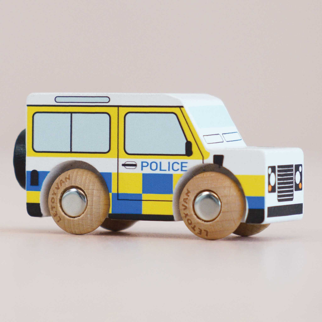 The No. 40 GT250 Bobby, made in England, is a wooden toy inspired by a classic British patrol vehicle. It features blue and yellow checkerboard patterns, black wheels, and the word “POLICE” on the side—perfect for imaginative play and striking against a plain light background.