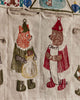 On the Coral & Tusk North Pole Advent Calendar, a fox in green with a sack and a bear in red with a scroll are embroidered facing each other on festive fabric for the Christmas countdown.