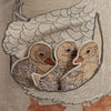 A detailed embroidery of three removable ducklings nestled within the wing of a larger bird, portrayed in shades of brown and cream on a Coral & Tusk Mama Duck Pocket Pillow.