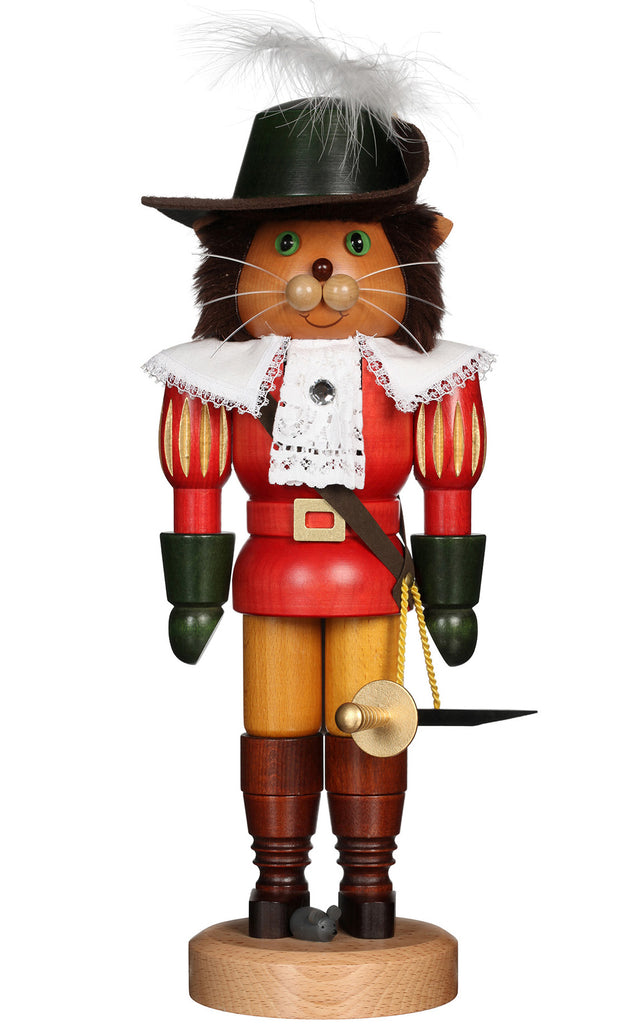 The Christian Ulbricht Collectible Wooden Nutcracker - Puss 'n Boots features a cat musketeer in a red and white outfit with green gloves, feathered hat, and sword, standing on a round wooden base. Made in Germany.