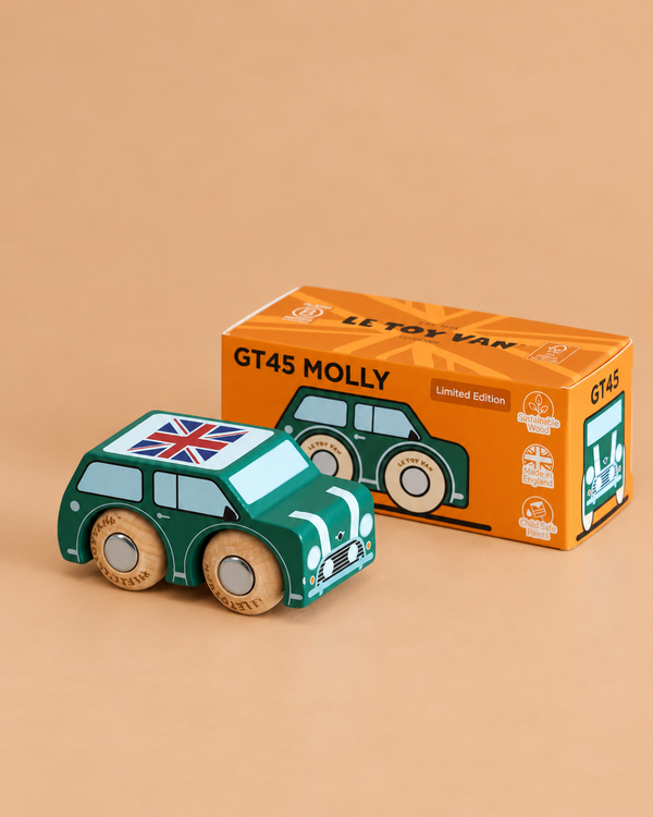 A green wooden car with a Union Jack on the roof is displayed next to its orange box labeled “No. 7 GT45 Molly | Made in England.” The box features an illustration matching the British toy car.