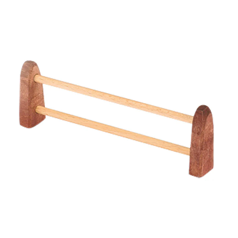 A small wooden display rack with two horizontal dowels connecting two U-shaped supports on each end, designed to hold or display the Ostheimer Large Fence. The rack is made from light and dark wood, showcasing its simple, minimalist design ideal for imaginative play.