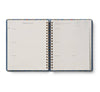 The 2027 Schoolhouse 17-Month Academic Hardcover Spiral Planner is open to a weekly layout for February 15–21, featuring lined sections for each day and monthly tabs visible along the right edge, illustrating its organized weekly and monthly planner format.