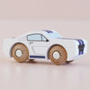 The No. 17 GT95 Maverick, a white wooden muscle car toy featuring blue racing stripes and natural wood wheels, is displayed against a plain light pink background.
