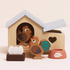 The Chicken Coop Playset is a delightful farmyard toy with a hen house, 2 wooden chickens, 3 eggs, a nest, and red food bowl. Made from FSC-certified wood, it features a heart-shaped window and blue roof.