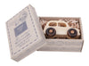 The Little Wooden French Car, a small natural wood baby toy, rests in a gift box with vintage-style designs and shredded paper, visible through the open lid.