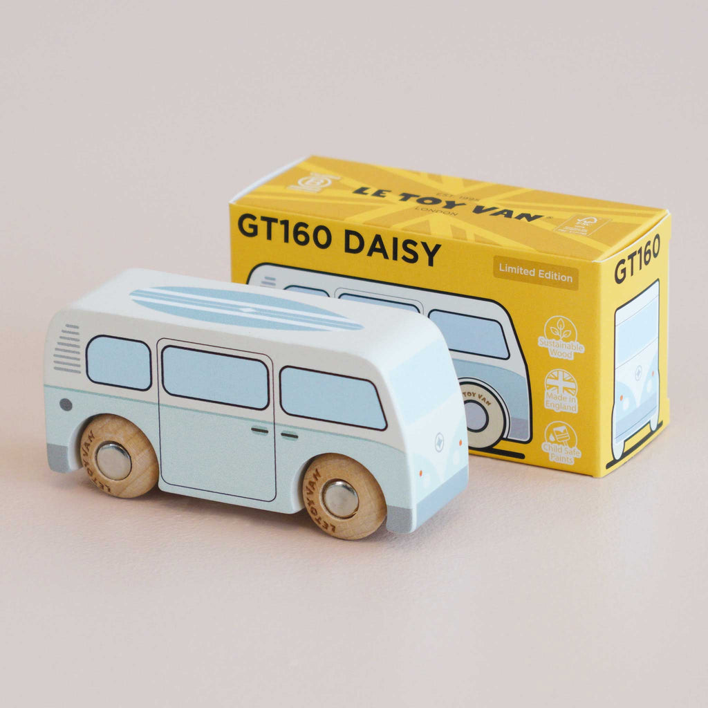 A retro toy wooden van, painted light blue, sits in front of its yellow packaging box labeled “No. 29 GT160 Daisy | Made in England.” The box features an illustration of the van and the text “Limited Edition,” making it perfect for nostalgic play or as a vintage wooden campervan collector’s piece.