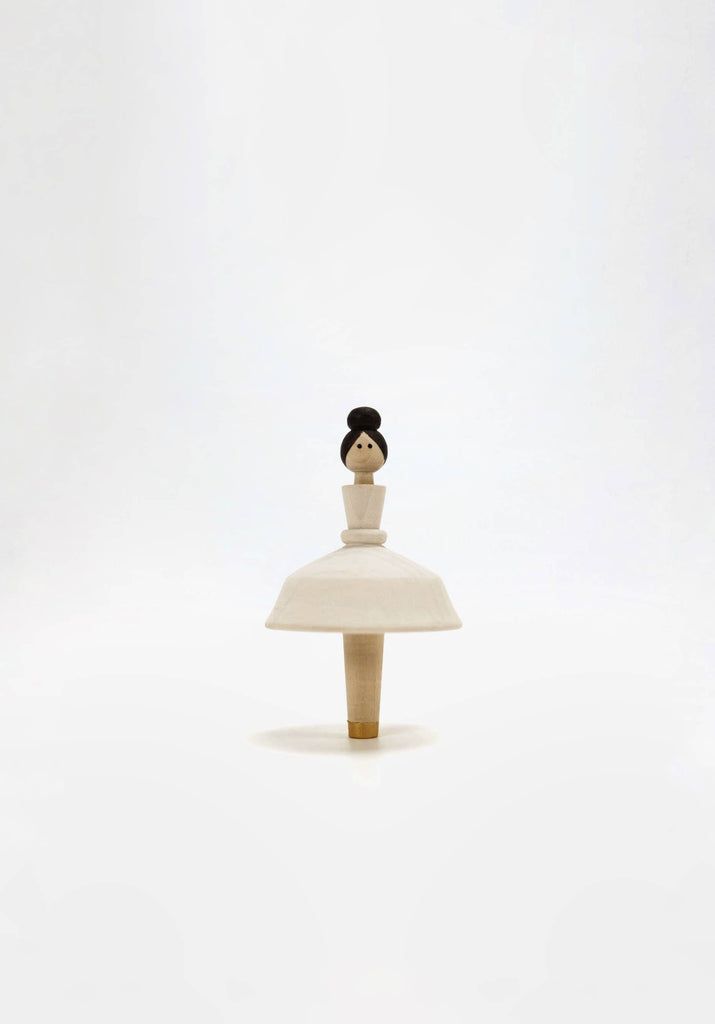 Introducing the Wooden Ballerina: a minimalist wooden figurine featuring a round base reminiscent of a dress, complete with a simple head and bun hairstyle. This hand-painted piece is crafted using water-based paint and captures the elegance of a ballerina, beautifully showcased against a plain white background.