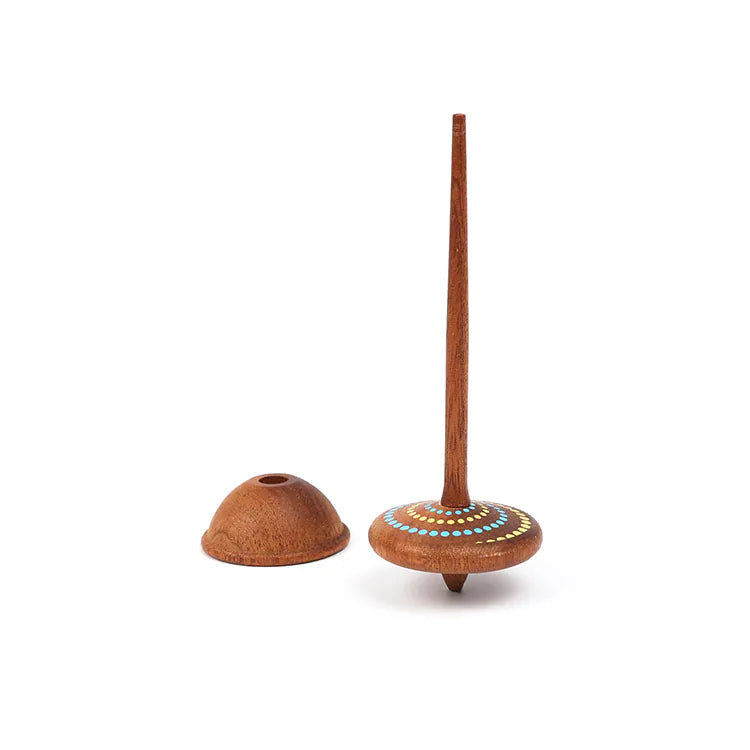 The Wooden Spinning Top - Long Stem, Dots, made from sustainable sapele wood with painted dots and a long handle, is displayed beside its matching holder on a white background.