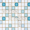 A Scrabble Bianco Edition game board featuring white tiles spelling “DREAM,” “OCEAN,” “MIRAGE,” and “CALM” arranged in a crossword pattern on a patterned blue and white grid.