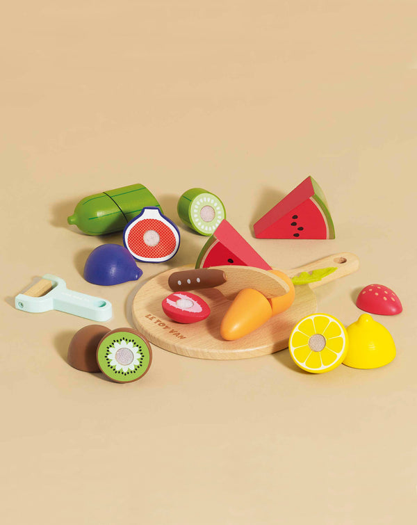 The Wooden Chopping Board & Sliceable Play Food set includes wooden fruit and veggies—a carrot, kiwi, lemon, watermelon, and avocado—plus a toy knife on a chopping board, perfect for role play kitchen fun.
