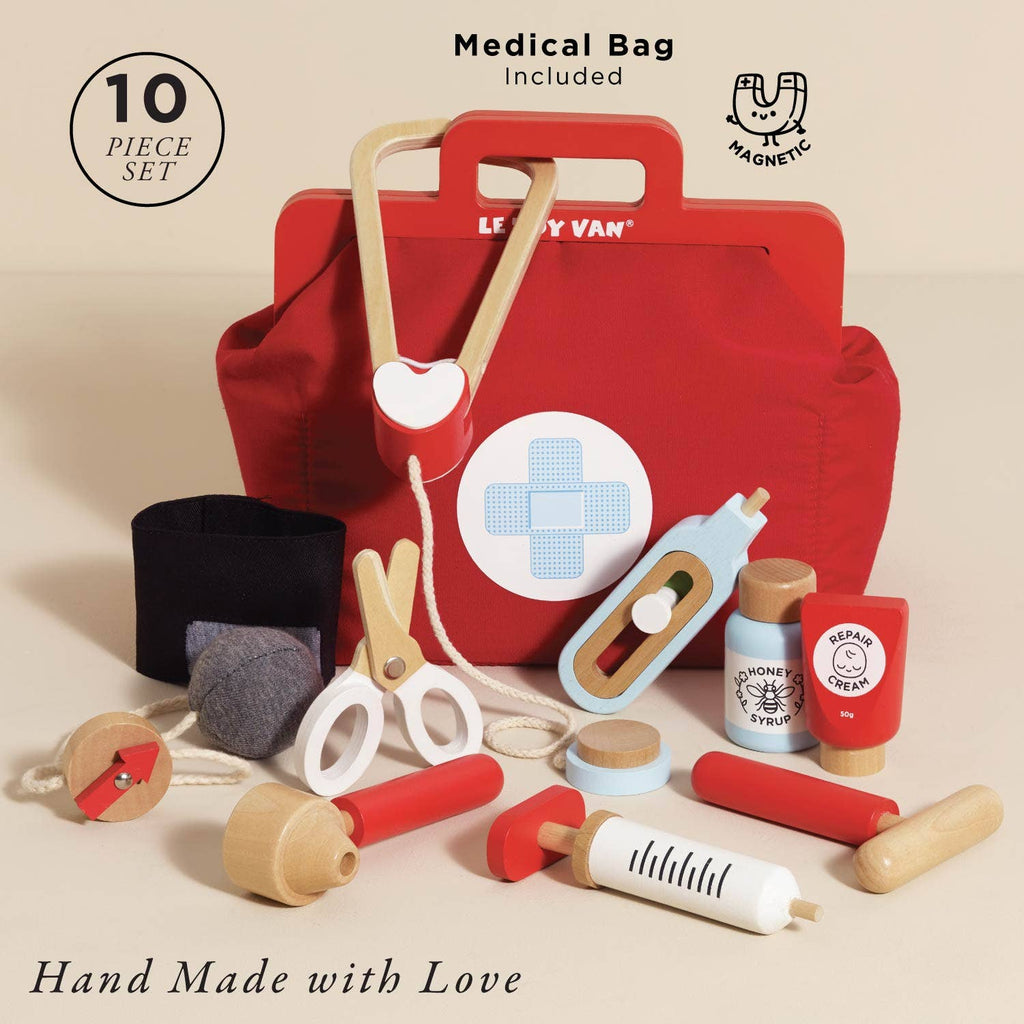 The Pretend Play Vintage Doctor Set features a red toy medical bag with a cross, plus wooden instruments like a stethoscope, syringe, scissors, medicine bottle, blood pressure cuff & ointment. Includes 10 pieces and "Hand Made with Love" text—perfect for kids' role play!.