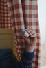 A child's hand holding a limited edition Grapat Advent Calendar (Final Sale) toy against a checkered red and white curtain backdrop.