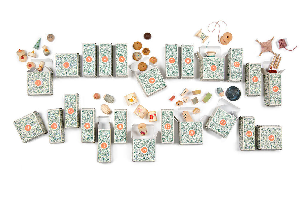 Decorative flat lay of numerous teal floral patterned boxes from the Grapat Advent Calendar (Final Sale), some opened revealing assorted knick-knacks including shells, beads, and tiny figurines, arranged on a