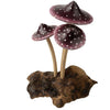 The Small Wooden Purple Mushroom Trio features three purple mushrooms with white spots and beige stems, growing from a driftwood base to create a charming decorative figurine.