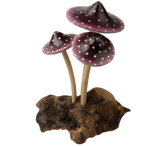 The Small Wooden Purple Mushroom Trio features three purple mushrooms with white spots and beige stems, growing from a driftwood base to create a charming decorative figurine.