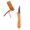 The Huckleberry Carving Knife (Not a Toy) features a wooden handle and short, pointed blade, shown beside its brown suede sheath with strap—ideal for beginner carving kits.
