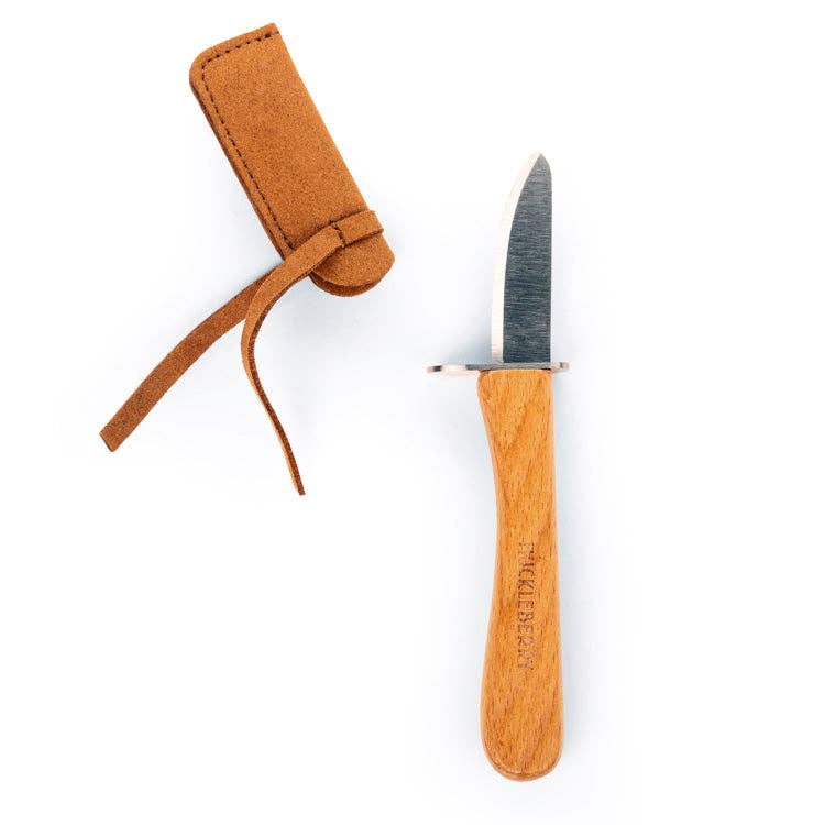 The Huckleberry Carving Knife (Not a Toy) features a wooden handle and short, pointed blade, shown beside its brown suede sheath with strap—ideal for beginner carving kits.
