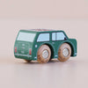 The No. 7 GT45 Molly, a small green wooden car with painted windows and details and sturdy wooden wheels, sits on a light, neutral surface—an endearing British toy made in England that evokes classic design.