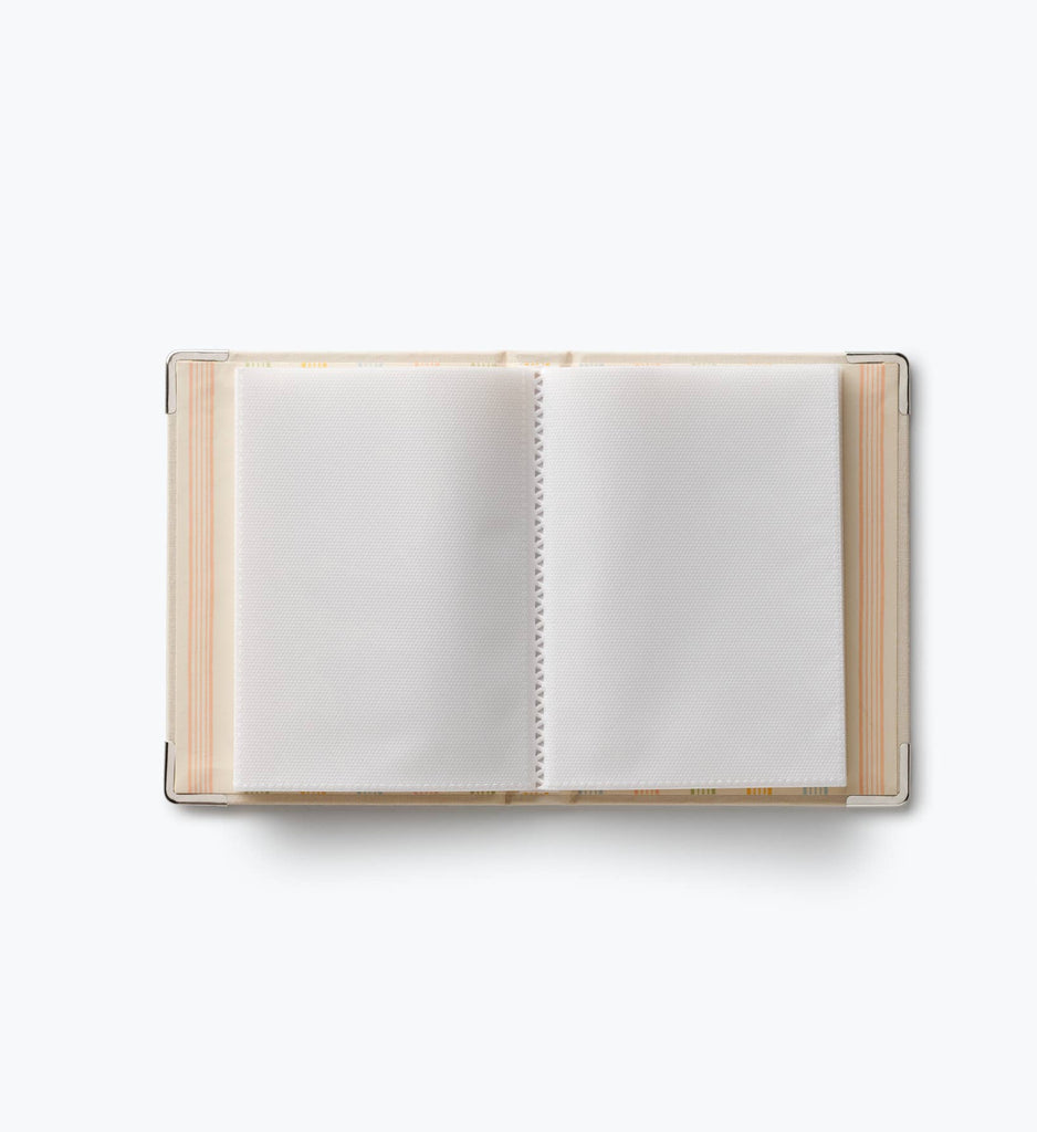 A Storybook Embroidered Small Photo Album with a beige cover and white plastic sleeves, open and empty, is centered on a plain white background.