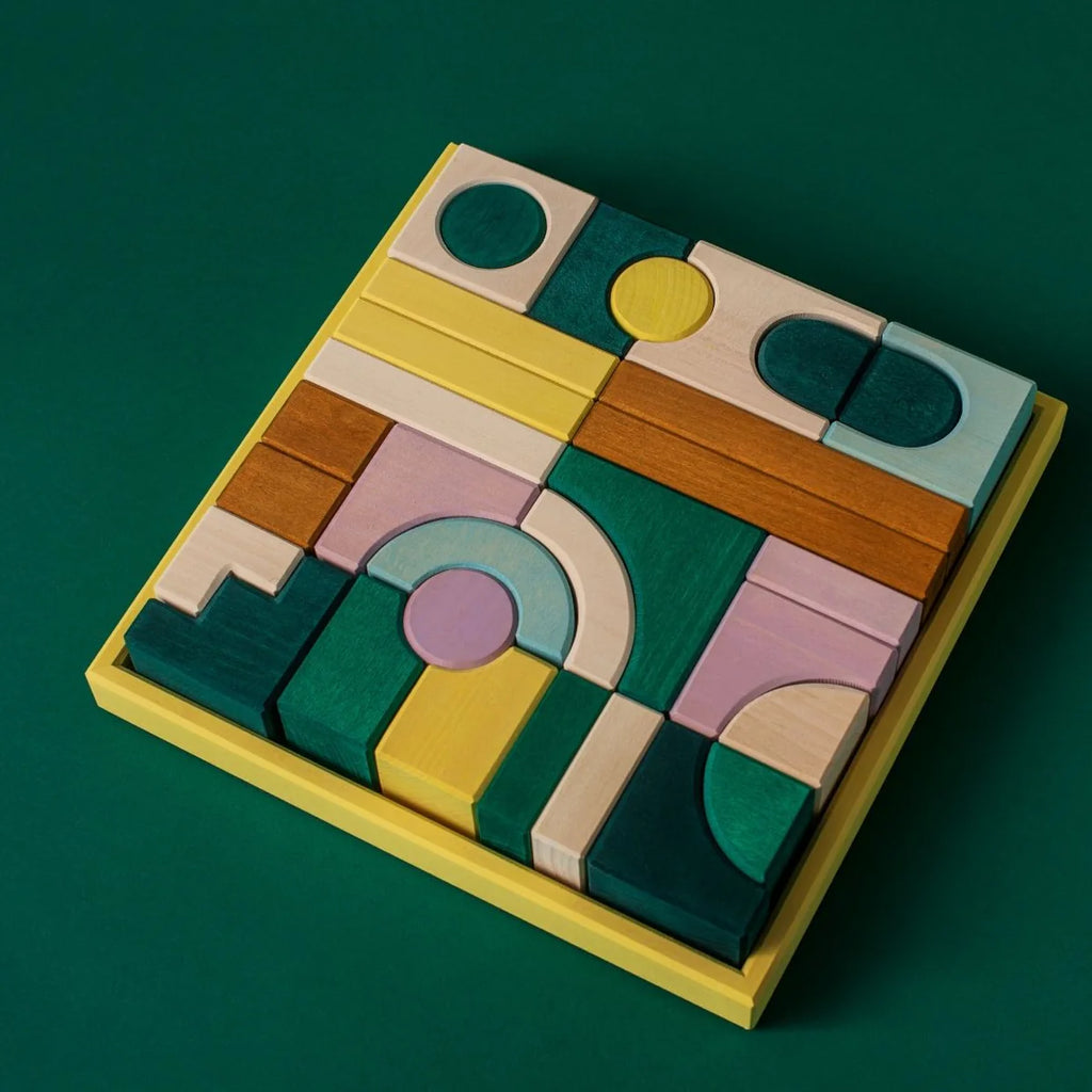 Grimm's Small Building Block Set - Movement: vibrant wooden blocks with geometric shapes and patterns, beautifully arranged in a square yellow tray—ideal for imaginative building and creative play.