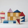 Grimm's Small Building Block Set - Rhythm features vibrant red, blue, and purple wooden blocks stacked into house-like sculptures from the TINY ART COLLECTION, set against a plain white background.