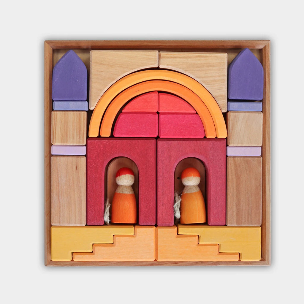 Grimm’s Building World - Desert Sand natural wood toys, including building blocks and two small wooden figures, arranged in a square frame to form an imaginative structure with arches, towers, and stairs.