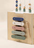 The Wooden Activity Cube is a stylish toddler toy with a pastel xylophone, mallet, and abacus designed to develop fine motor skills.
