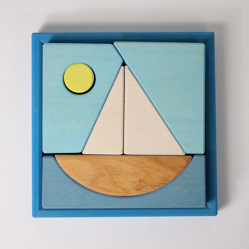 Grimm's Building Set - Blue: Colorful wooden blocks arranged in a blue square frame form a sailboat scene with water and a yellow sun—perfect toddler toys for creative play.